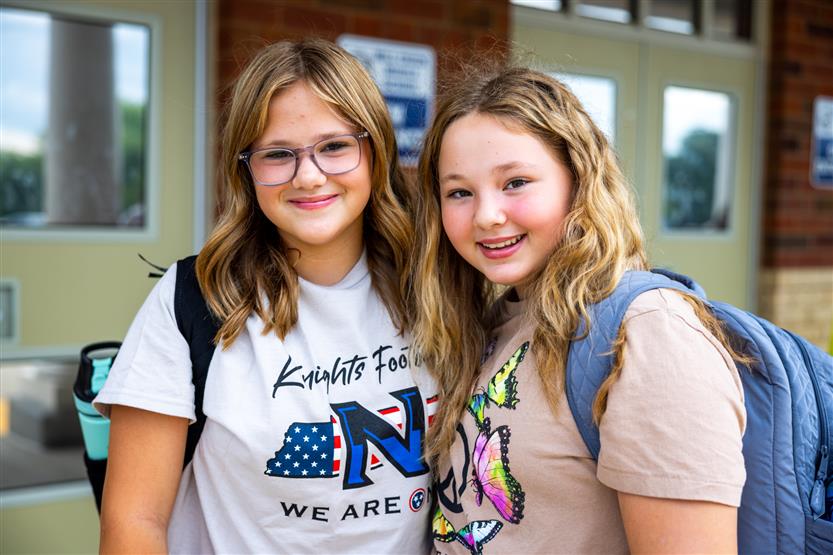 Two students smile